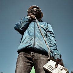 man in blue jacket and blue denim jeans wearing black headphones