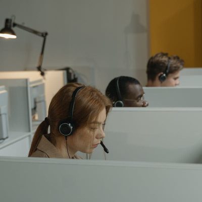 Diverse call center agents focused on their tasks in a modern workspace with headsets.