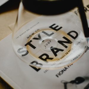 Photo by Eva Bronzini A coffee pot rests atop a book titled 'How to Style Your Brand', capturing the essence of creative branding.