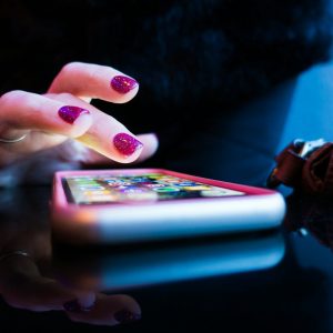 Photo by Rob Hampson person using black smartphone with gray and pink case