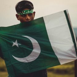 Photo by Ali Muhammad a young man holding a flag in his hands