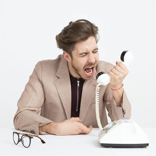 Photo by Icons8 Team man holding telephone screaming