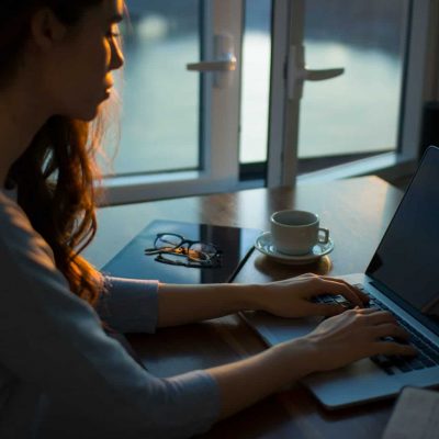 woman sitting beside table using laptop