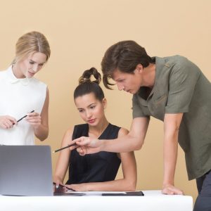 Photo by Icons8 Team man teaching woman while pointing on gray laptop